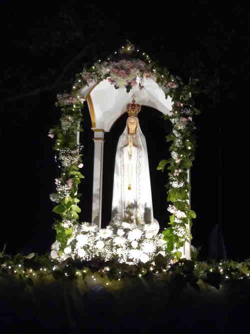 Our Lady of Fatima Statue on a beautiful float with flowers and lights in procession. Our Lady of Fatima Statue on a beautiful float with flowers and lights